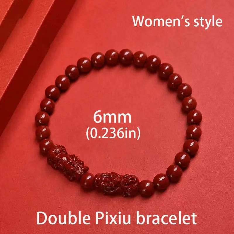 Red jade bracelet with two intricately carved pixiu charms in purple gold cinnabar is a hand carved double pixiu bracelet.