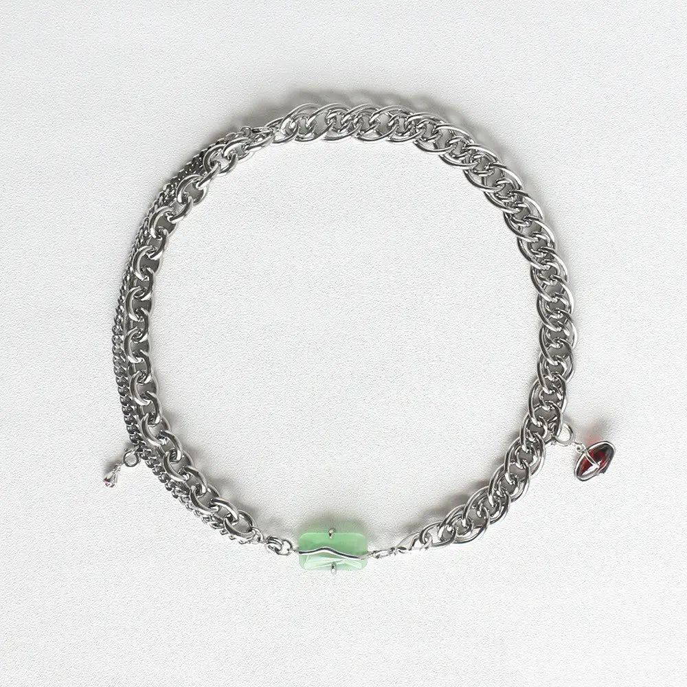 Layered silver opal and zircon crystal charm necklace featuring a silver-toned chain with a layered design, a central light green jade-like pendant, and a small red gemstone charm.