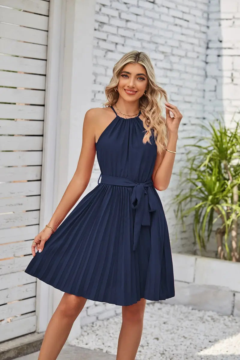 A navy blue halter neck pleated chiffon mini dress with a matching belt tied at the waist.
