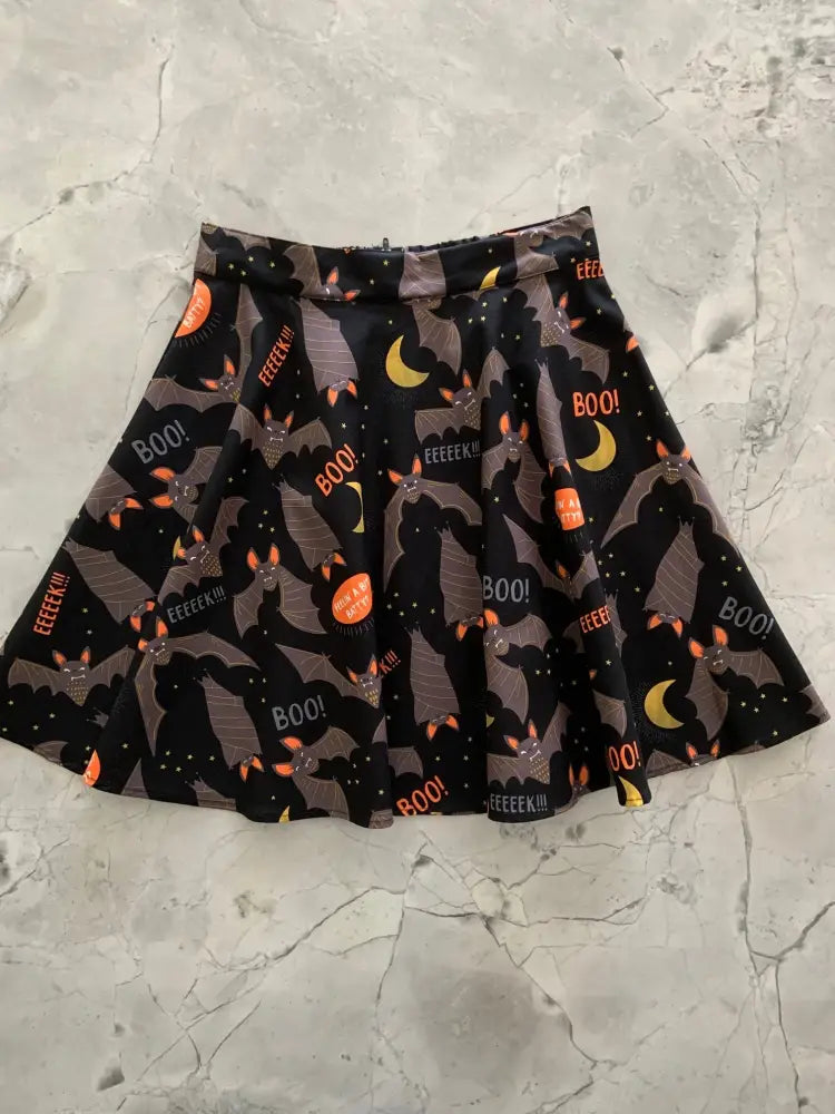 Feelin batty plus size 1x halloween skater skirt in black pleated fabric with orange bats yellow moons and boo print