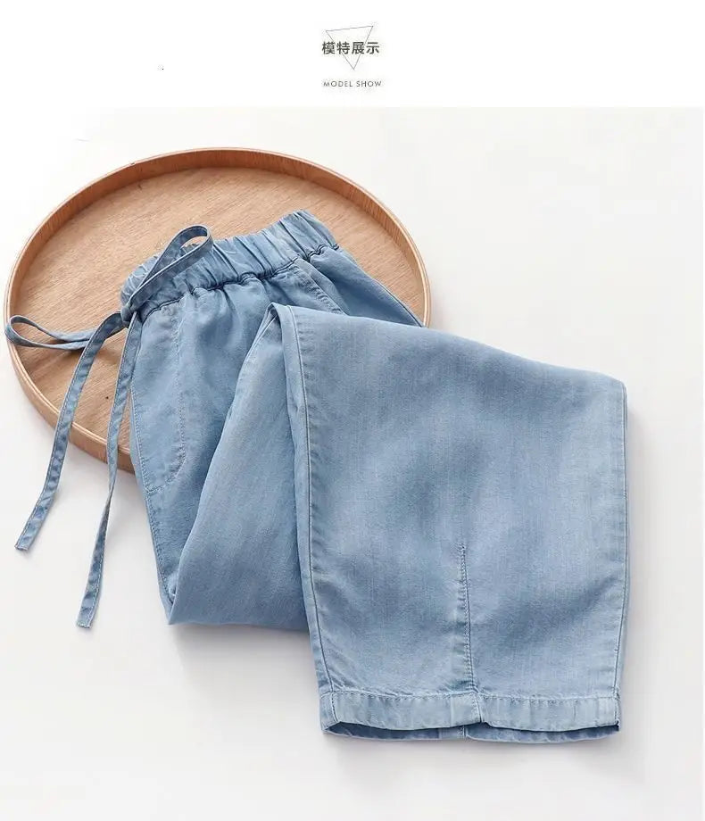 Light blue denim harem jeans high waisted drawstring pants featuring an elastic waistband.