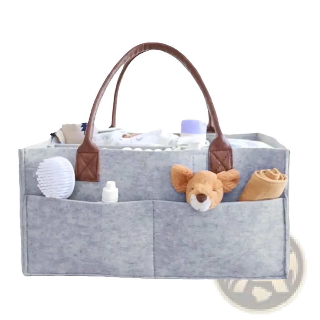 Gray felt baby diaper caddy organizer bag with brown leather handles and multiple compartments holding baby care items