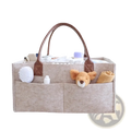 Beige felt diaper caddy nursery storage basket with brown leather handles and multiple compartments for baby care organization