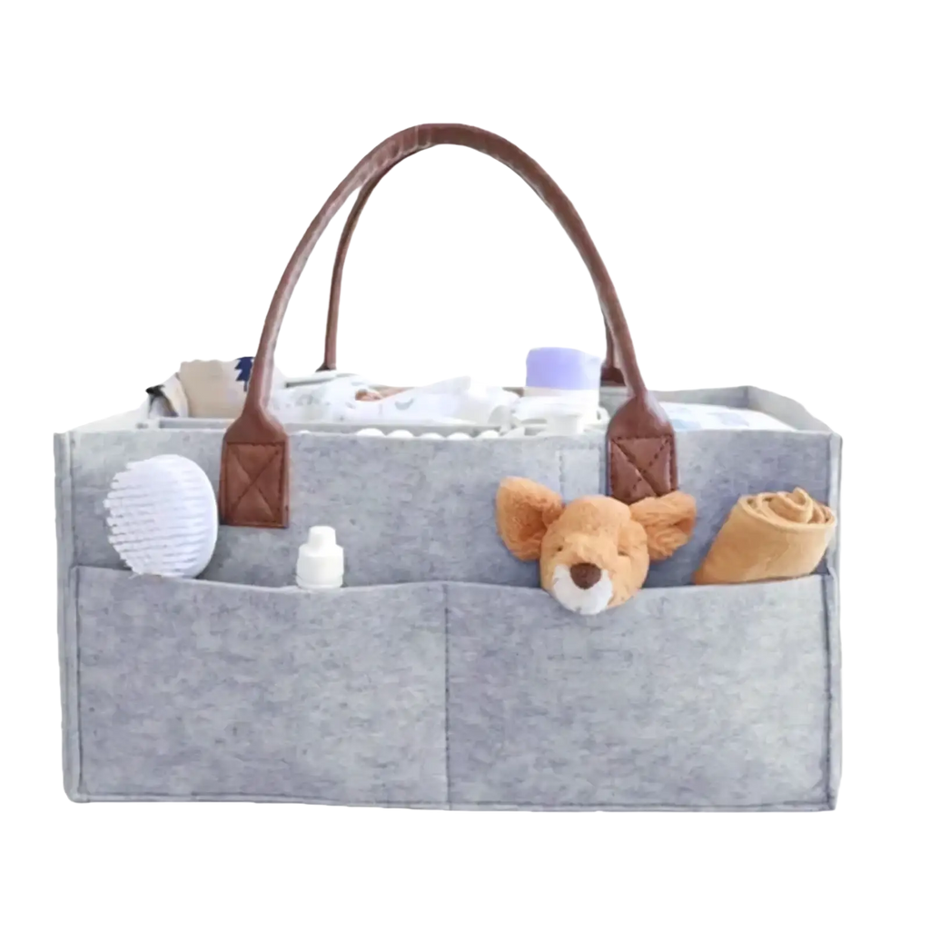 Gray felt diaper caddy nursery storage basket with brown leather handles and multiple compartments holding baby care items