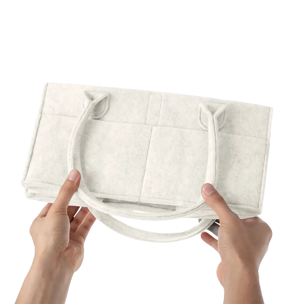 Off-white felt diaper caddy nursery storage basket with soft padded handles and collapsible design for easy storage
