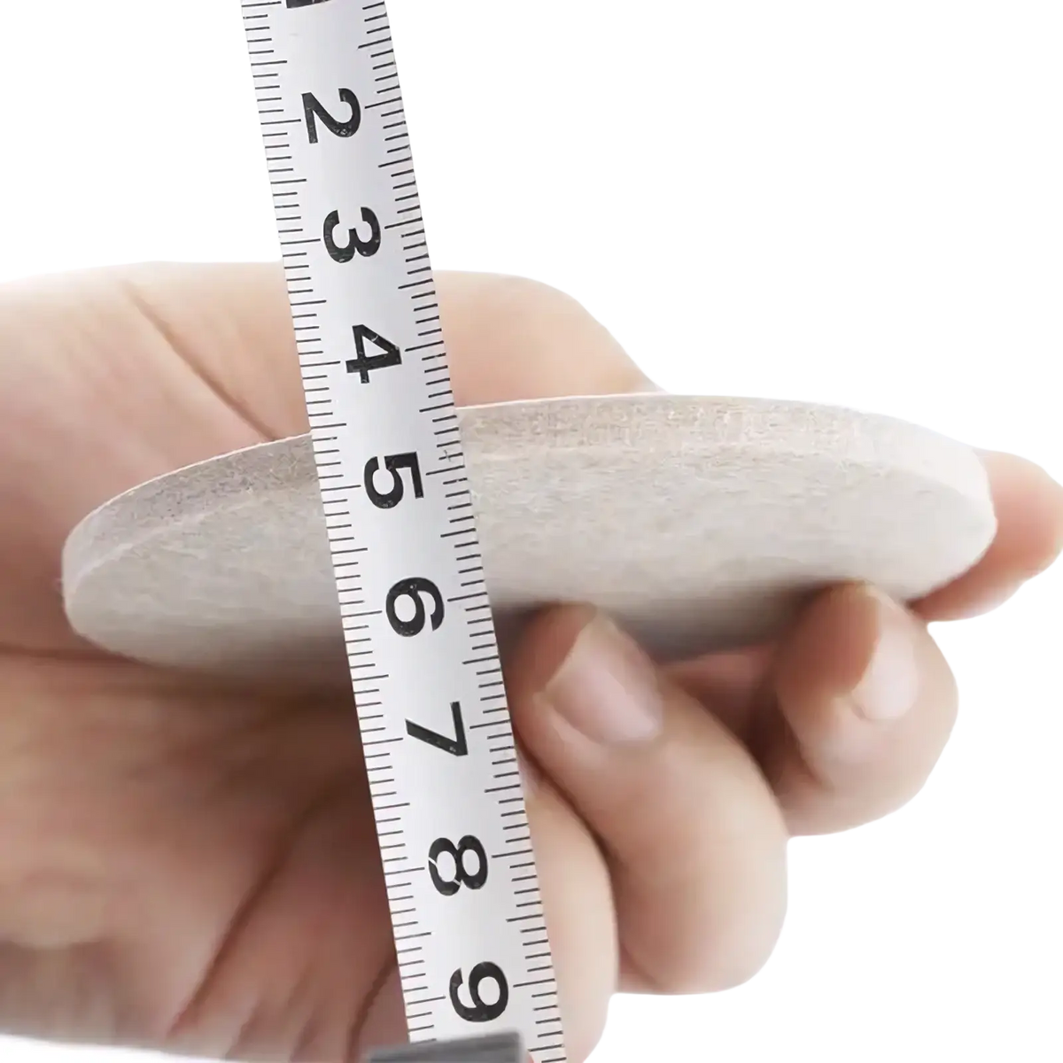 A 5mm thick off-white circular felt furniture pad held next to a ruler for floor protection