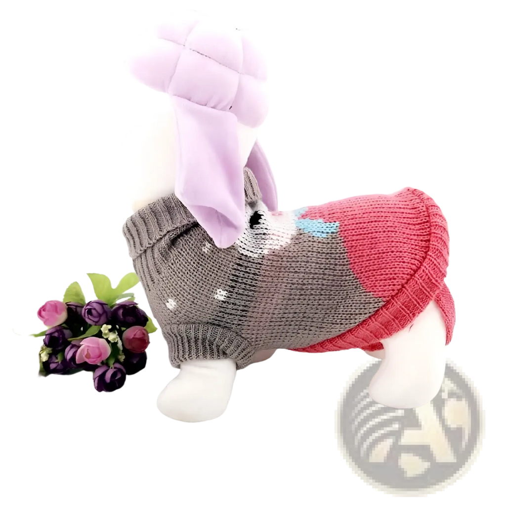 A plush white dog toy wearing a gray pink and light blue knitted festive knit pet sweater for winter apparel