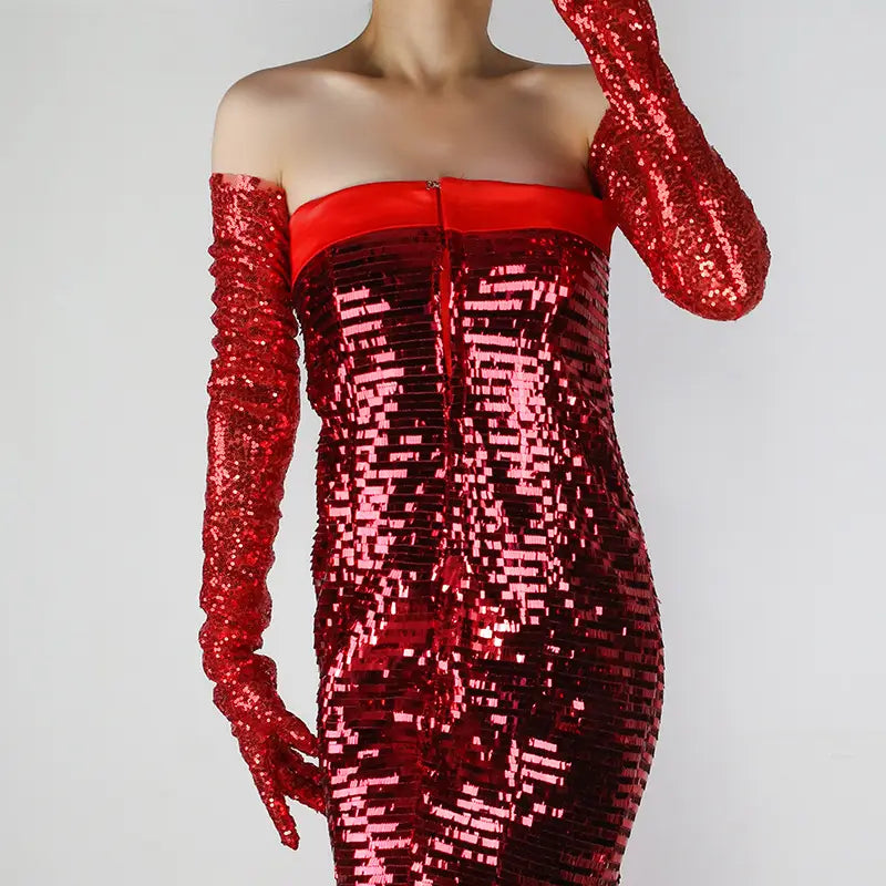 A shimmering red sequined strapless dress with a fitted silhouette paired with long matching sequined mesh finger gloves.