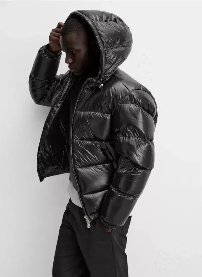schwarze glänzende wattierte Kapuzen-Steppjacke mit glänzender Oberfläche und isolierendem Design, geeignet für kaltes Wetter.