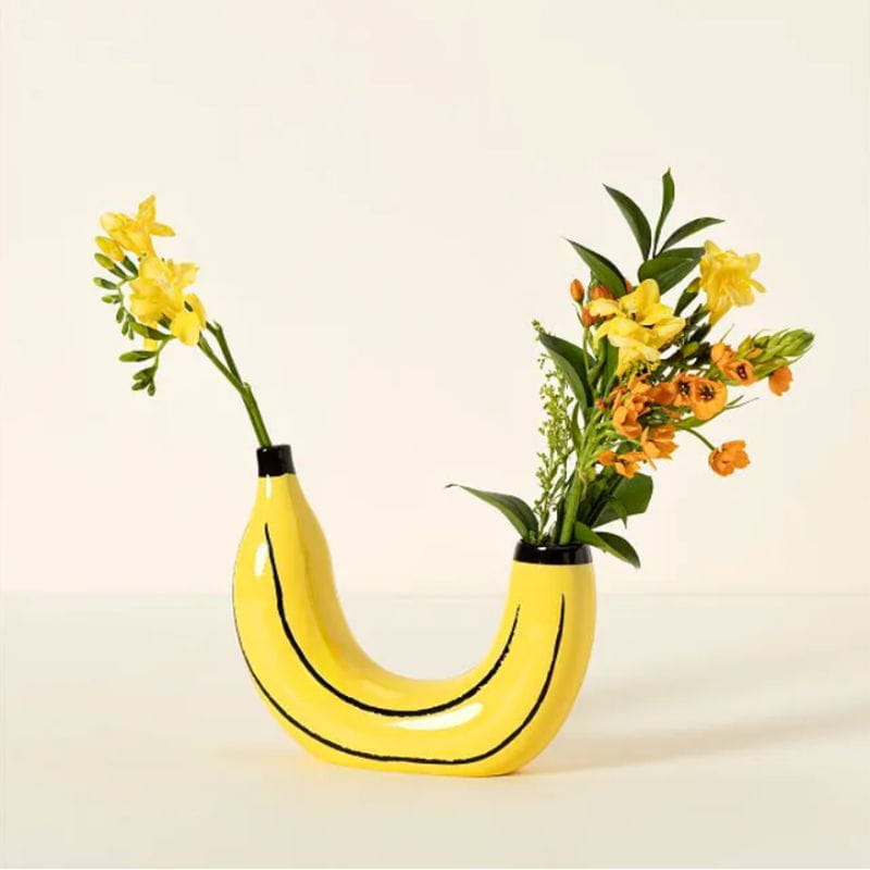 Yellow banana-shaped ceramic vase with black curved lines and a black rim for home decor.