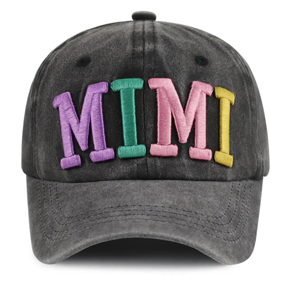 A dark gray distressed baseball cap with rainbow mimi embroidered in colorful raised letters in purple green pink and yellow.