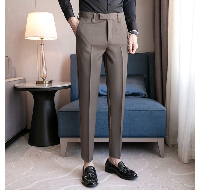 A pair of men’s slim fit British style tailored straight leg trousers in muted taupe made from smooth structured fabric.