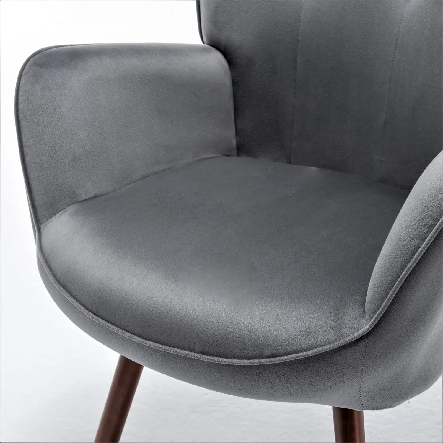 Ein eleganter Mid-Century-Wingback-Akzentstuhl, mit weichem grauem Samt bezogen, mit minimalistischer Gestaltung und dunklen Holzbeinen.