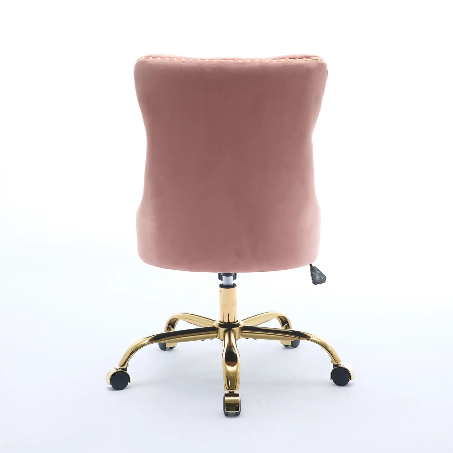 Un fauteuil de bureau rembourré en velours rose poudré, à capitonnage, avec une base en métal finition dorée et cinq roulettes pour la mobilité.