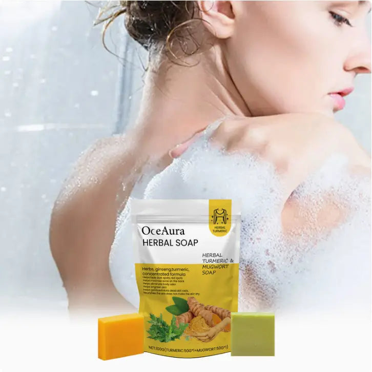 Oceaura turmeric and mugwort herbal soap bar set with two bars in a white and yellow pouch featuring one orange and one green soap bar.