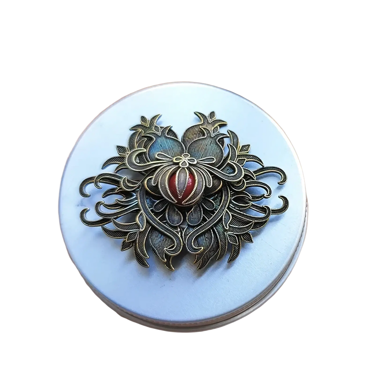 Antique bronze filigree brooch with intricate floral and pomegranate design featuring a central red gemstone accent