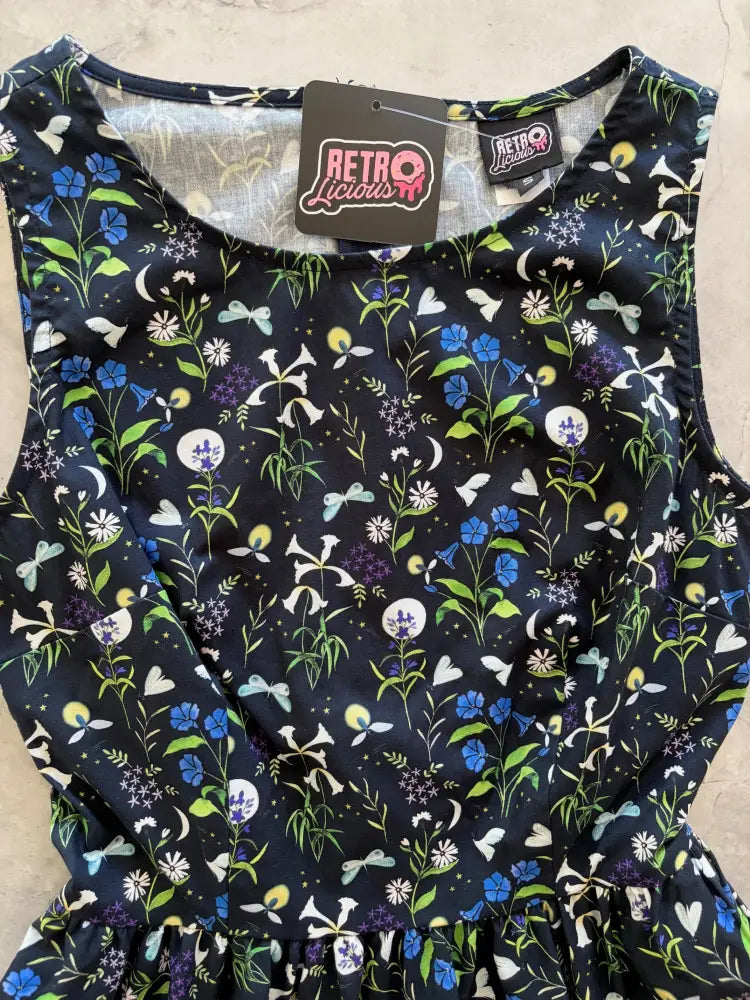 A navy blue cotton 1950s style midi dress with vibrant floral and insect print and pockets