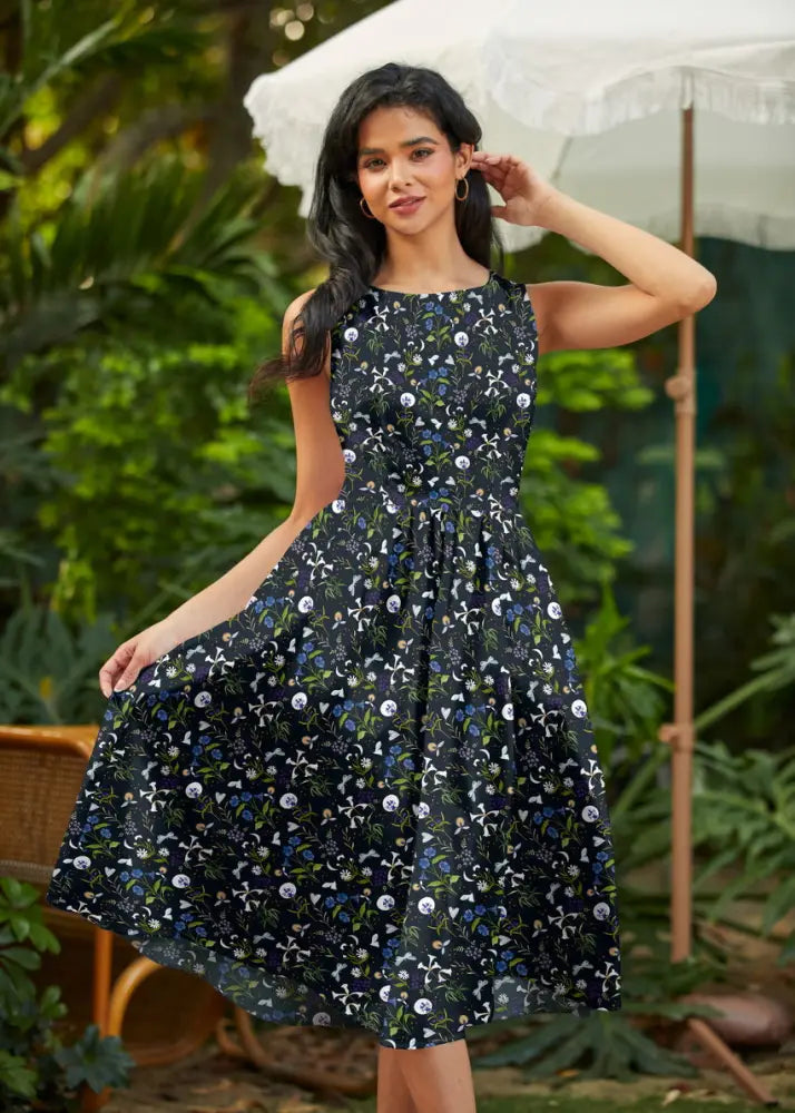 A navy blue sleeveless cotton midi dress with white light blue green floral pattern and pockets in 1950s style