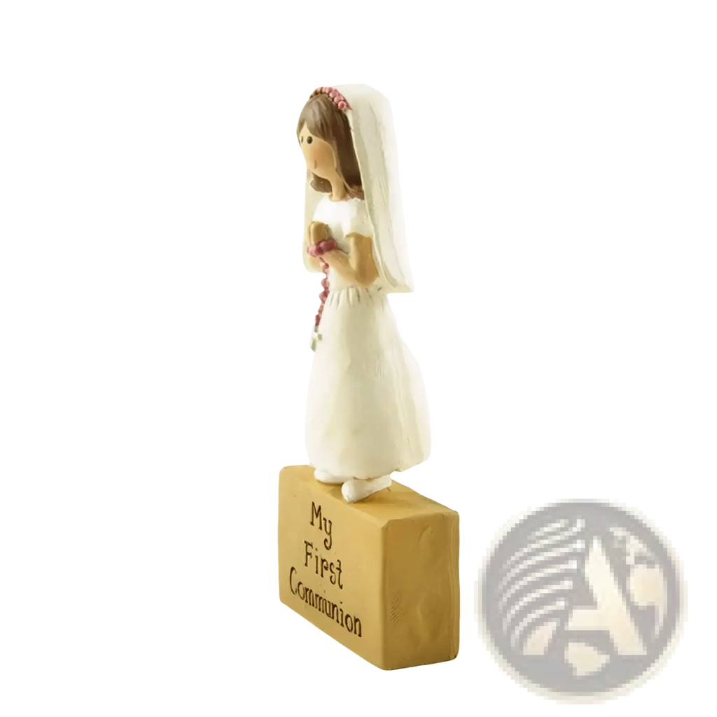 White resin first communion girl figurine in dress with veil and pink headband holding rosary beads for tabletop decor