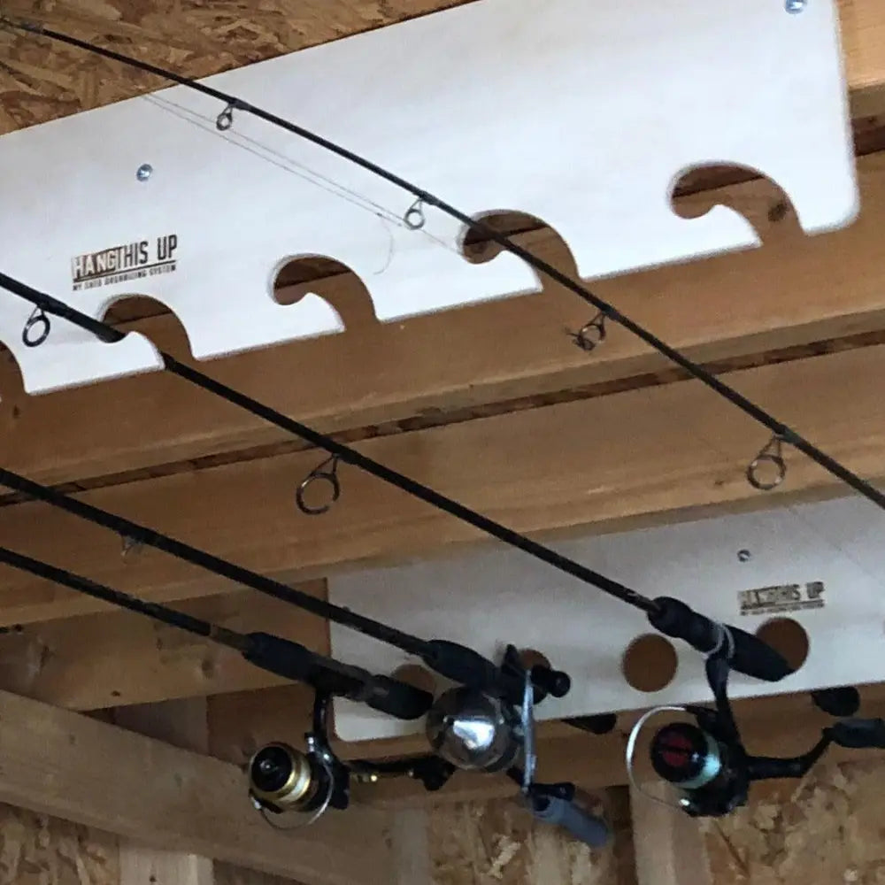 White plastic fishing rod holder with curved cutouts and hang this up branding for handcrafted wooden fishing pole storage rack