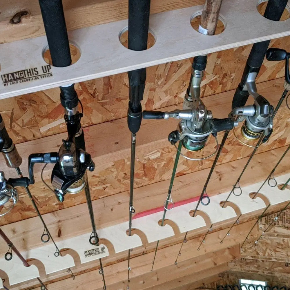 Handcrafted white wooden fishing pole storage rack with circular cutouts holding multiple black and silver rods