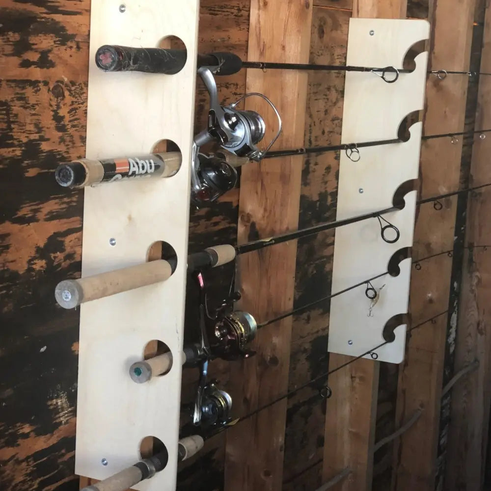 Handcrafted light-colored wooden fishing pole storage rack with multiple slots holding various rods and reels