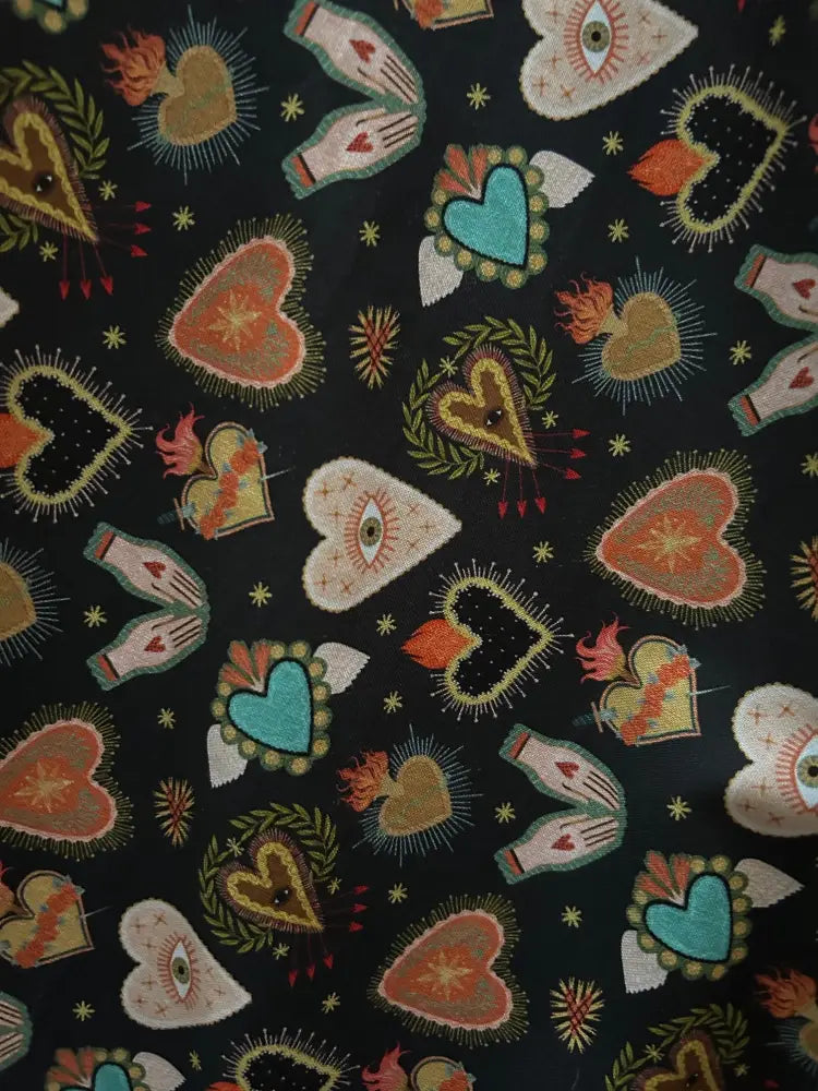 Black cotton flaming hearts 1950s style midi dress with pockets featuring teal gold and cream embroidered heart patterns