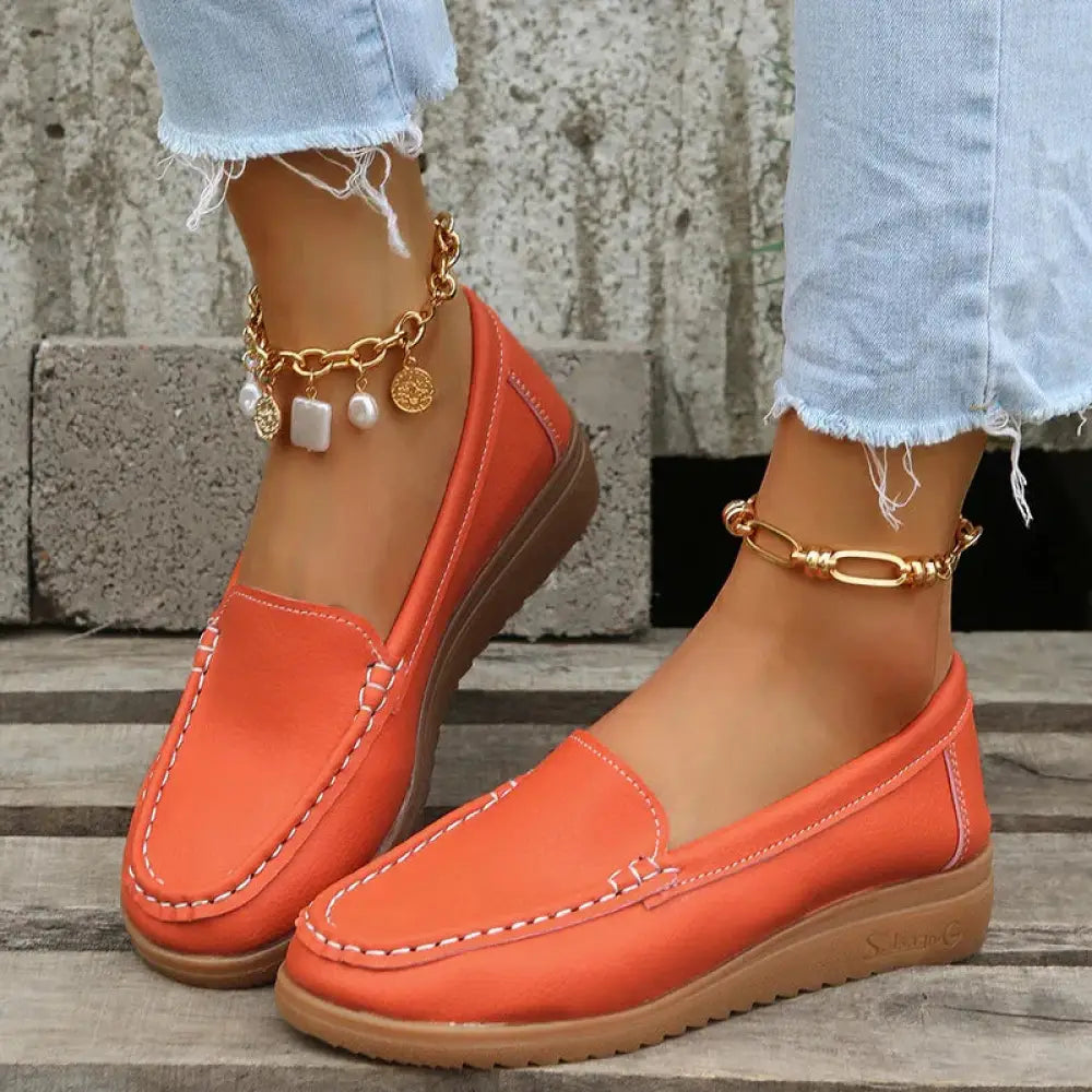 Bright orange women’s slip on pu leather loafers with white contrast stitching and cushioned sole