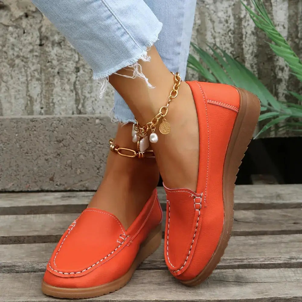 Women’s slip on pu leather loafers in bright orange suede with white contrast stitching and tan rubber sole