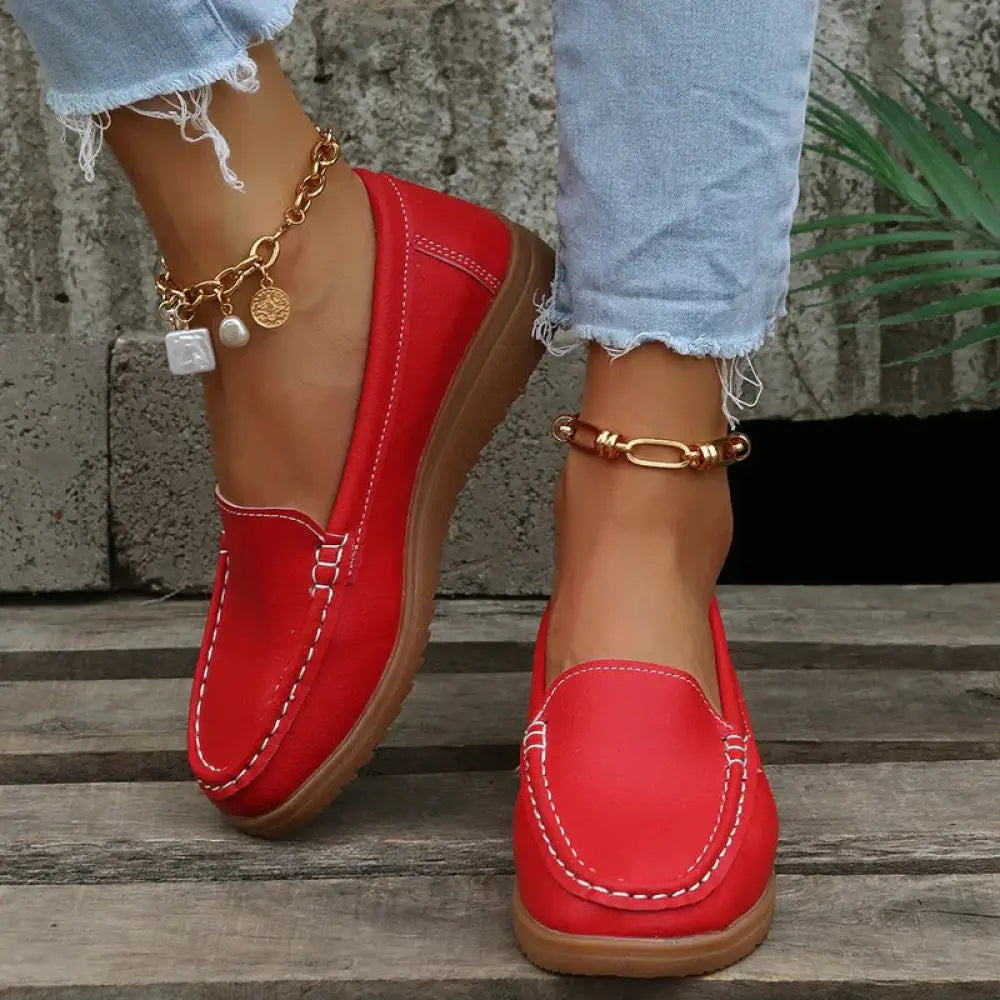 Women’s slip on red pu leather loafers with white contrast stitching and tan rubber sole