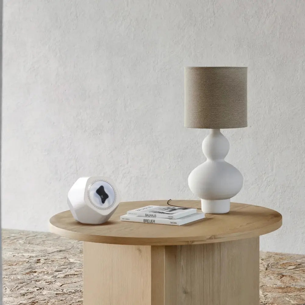 White ceramic table lamp with beige fabric shade and dual-gourd base shown with hexagonal magnetic fluid bluetooth speaker and visualizer