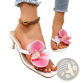 White heeled floral block heel mule sandals featuring large pink orchid flower decoration on a flip-flop design