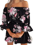 Black off-the-shoulder floral boho mini dress with pink and white roses on flowing ruffled fabric
