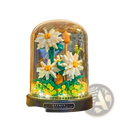 Floral building block bouquet featuring a delicate white daisy arrangement in colorful blocks under a glass dome with warm lighting