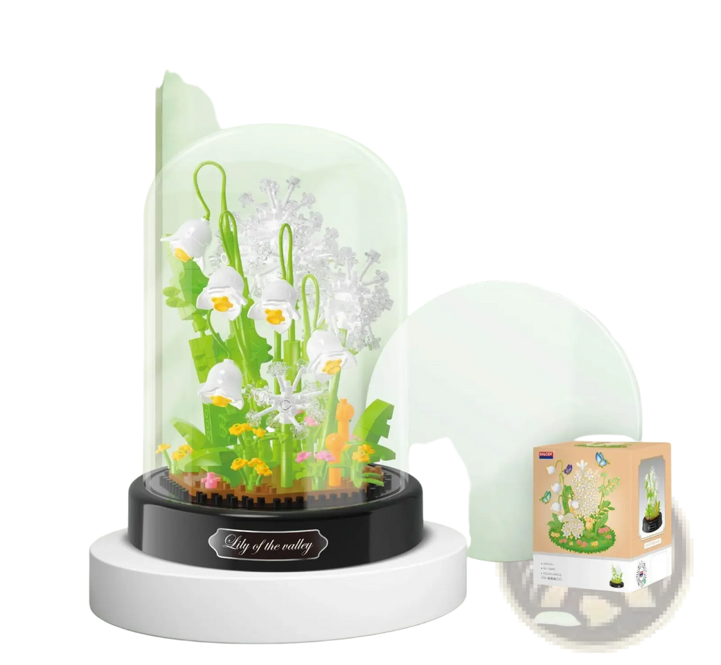 Floral building block bouquet in glass dome with delicate white and green lily of the valley plastic flowers on black base