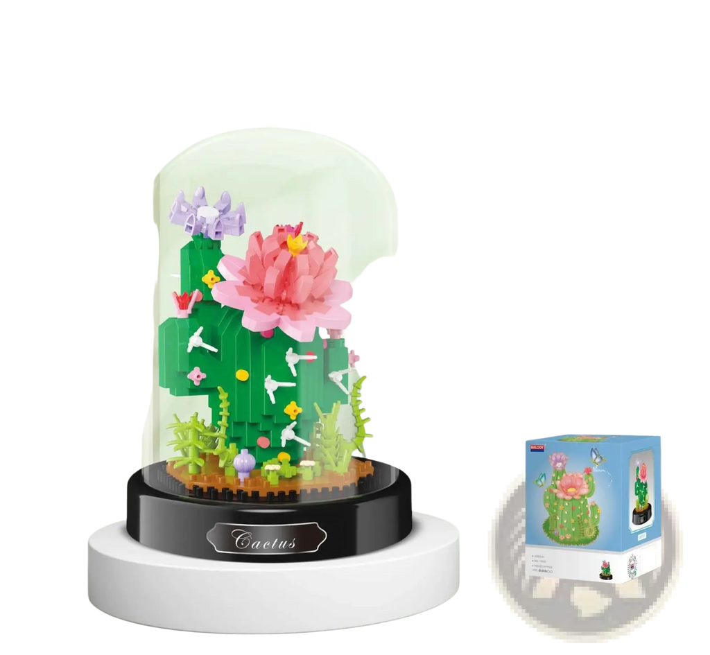 A vibrant green floral building block cactus with a large pink flower and small white birds under a glass dome