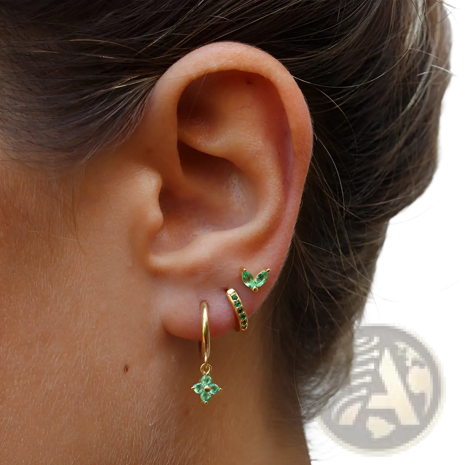 Gold hoop earring set with floral and butterfly design featuring emerald green gemstones in a gold tone