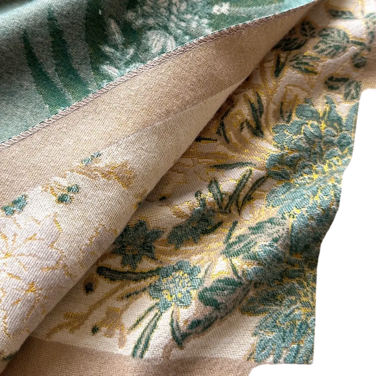 Beige floral cashmere winter scarf shawl with intricate green and gold embroidery on soft fabric surface