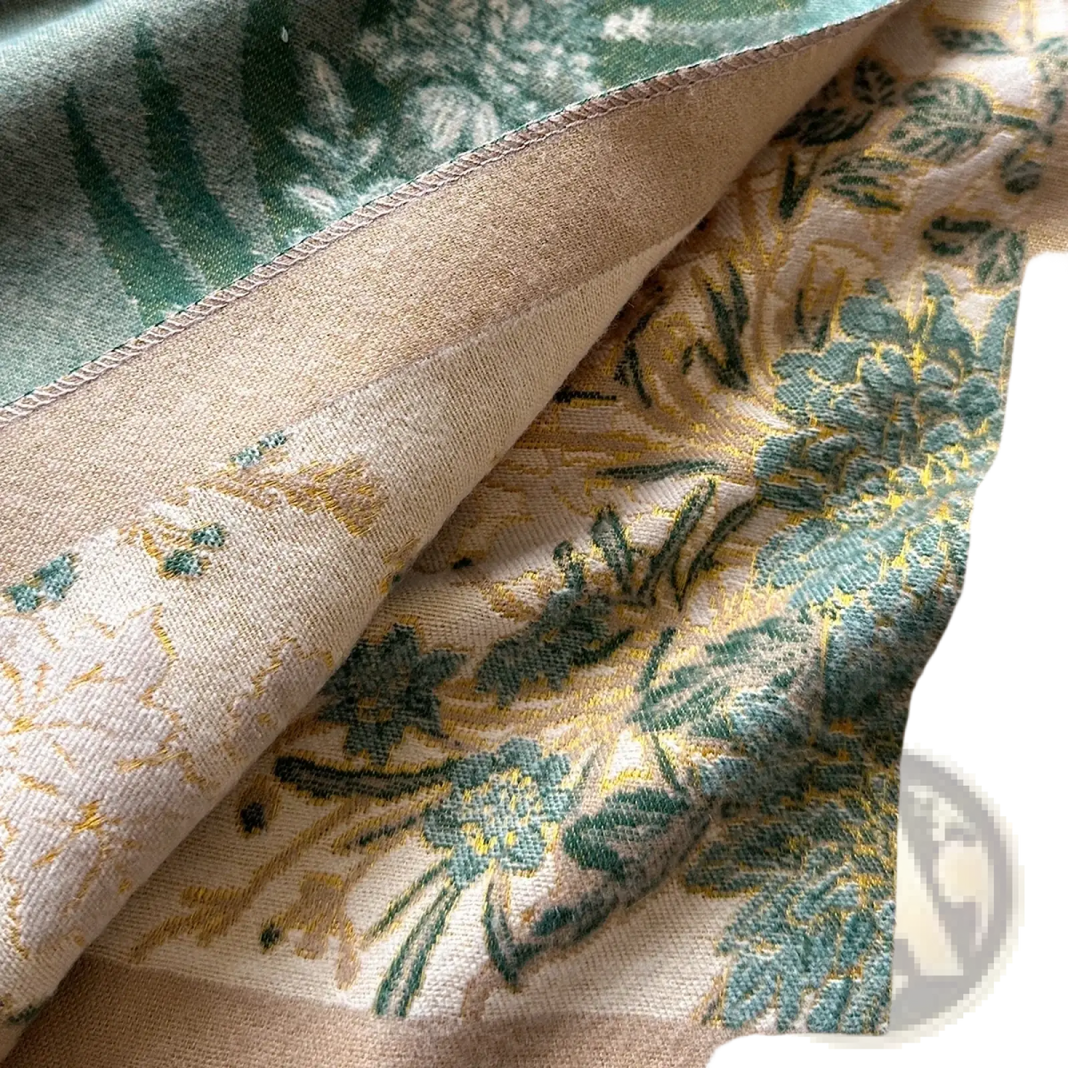 Beige floral cashmere winter scarf shawl with intricate green and gold embroidery on soft fabric surface