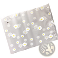 Floral clear travel cosmetic bag with translucent white plastic, white daisy pattern, and clear zipper closure