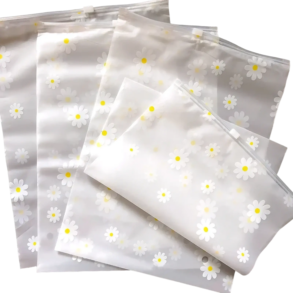 Floral clear travel cosmetic bag made of clear plastic featuring a delicate pattern of white daisies with yellow centers