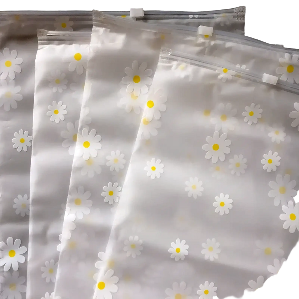 Floral clear travel cosmetic bag made of clear plastic with white daisies and yellow centers delicate pattern