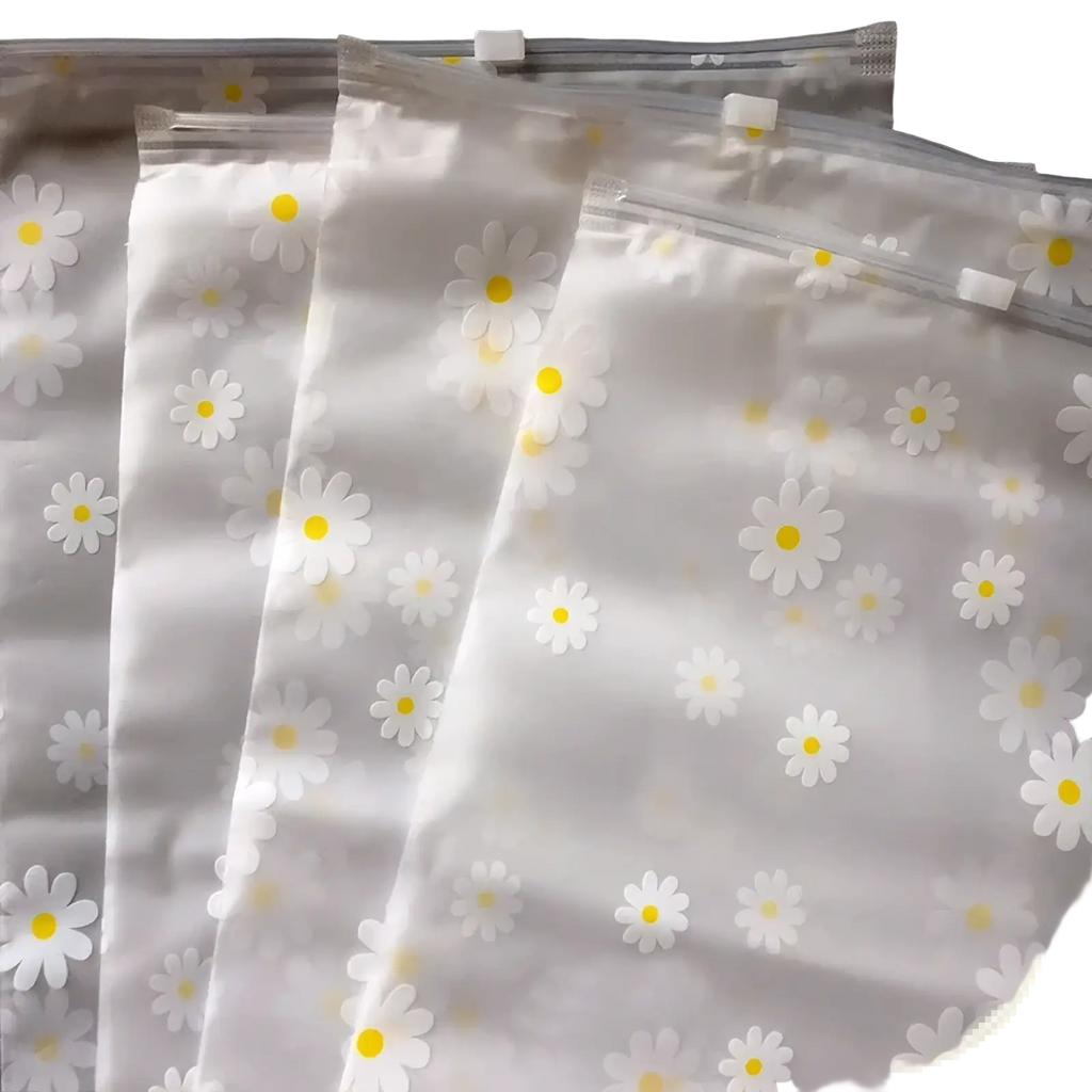Floral clear travel cosmetic bag made of clear plastic with white daisies and yellow centers delicate pattern