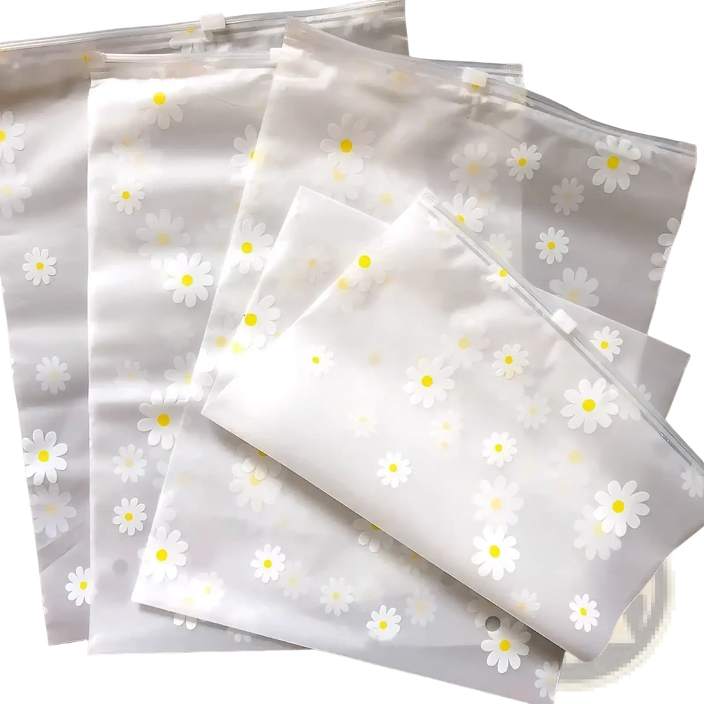 Floral clear travel cosmetic bag made of clear plastic featuring a delicate pattern of white daisies with yellow centers