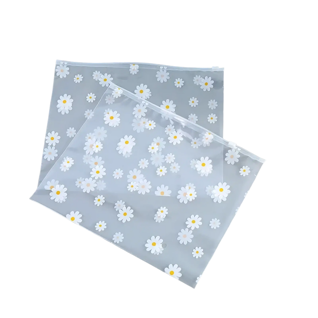 Floral clear travel cosmetic bag made of clear plastic with white daisies and yellow centers zip-top closure