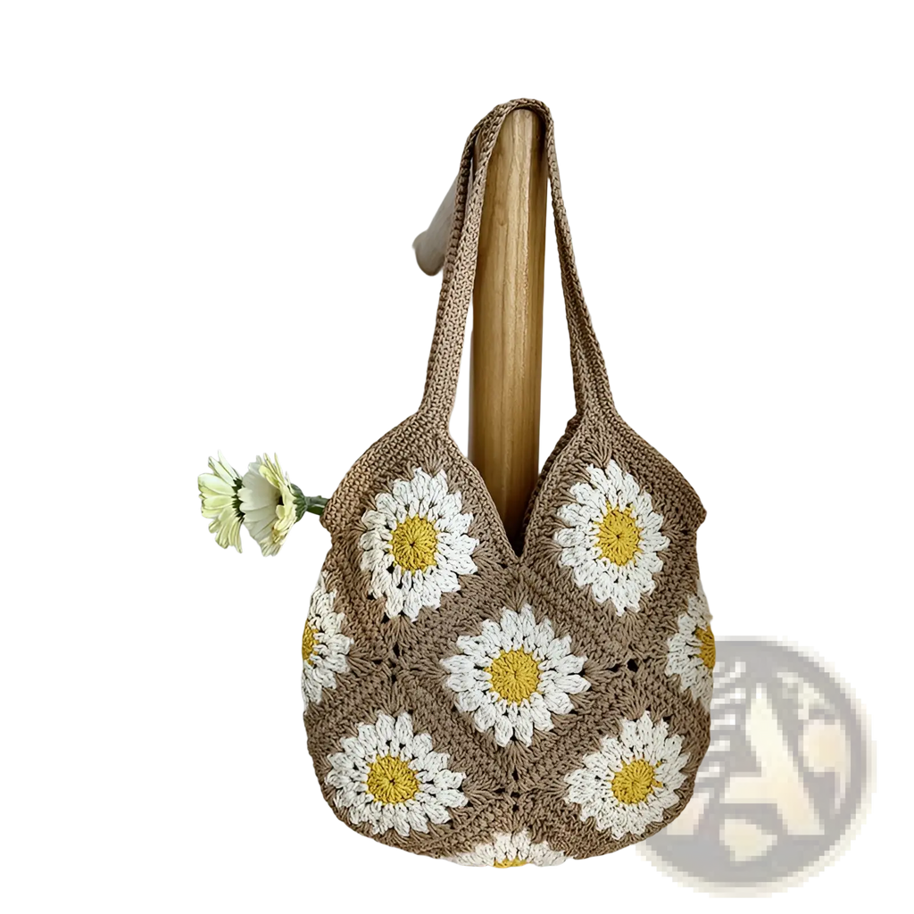 A beige crocheted floral tote bag featuring white and yellow daisy motifs for stylish shoulder use