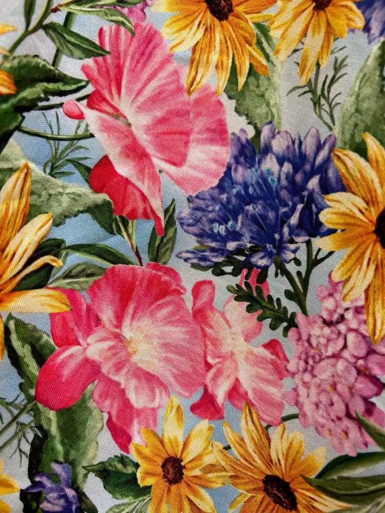 Floral Doris retro cotton midi skirt with pockets featuring vibrant pink yellow and purple blossoms on blue background