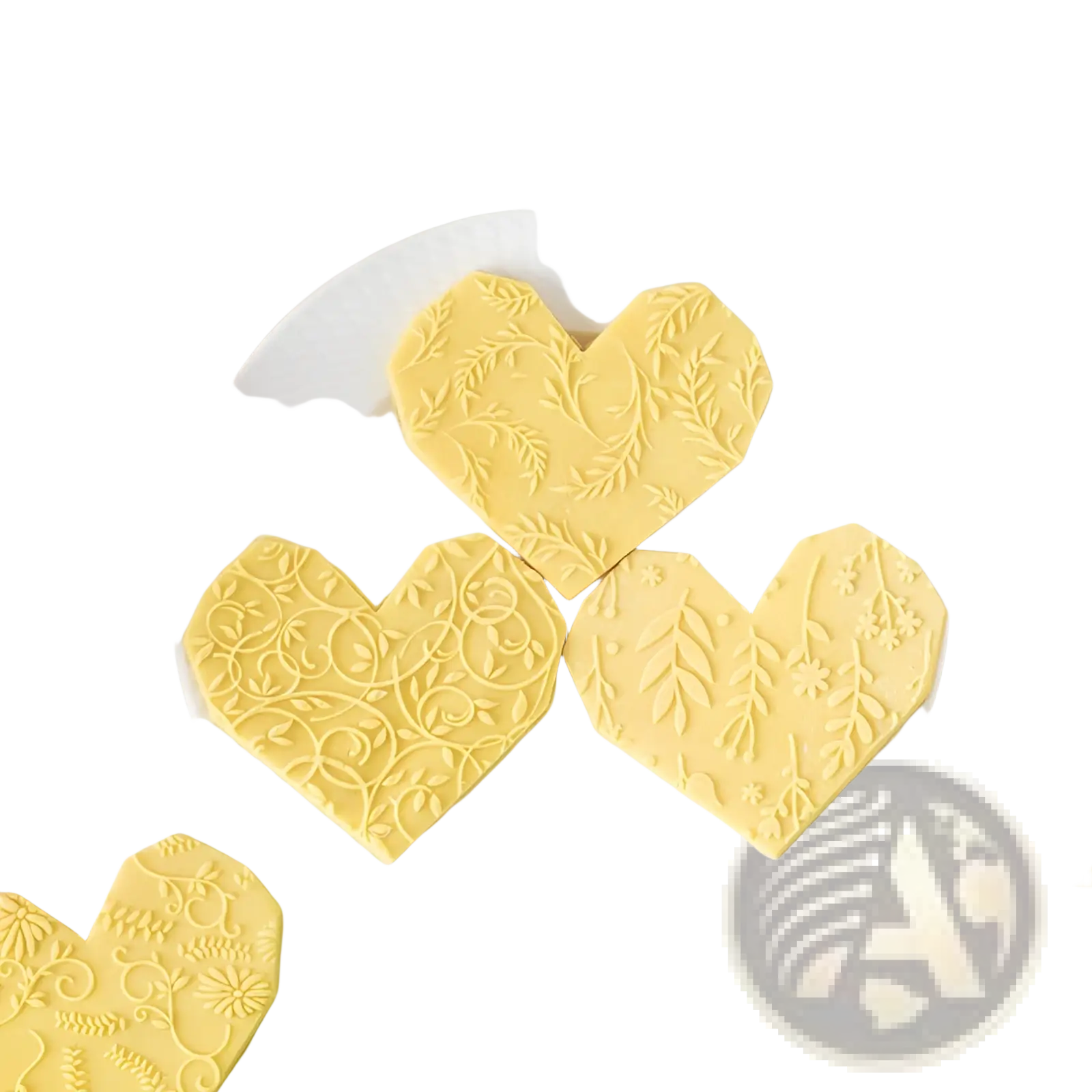 Yellow heart-shaped cookies with intricate floral embossing made using a floral embossed beech wood rolling pin for baking