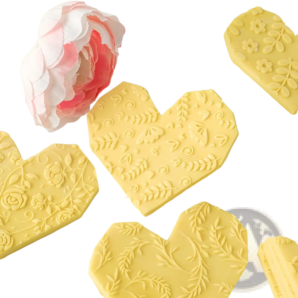 Yellow heart-shaped chocolate pieces with floral and leaf embossing made using a floral embossed beech wood rolling pin
