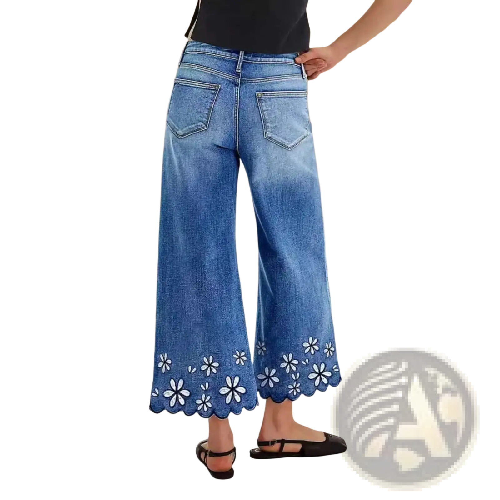 Blue denim wide-leg pants with scalloped hem and white floral embroidery in a cropped floral embroidered design